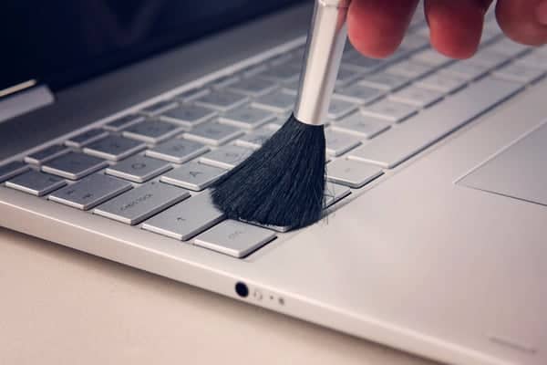 Use make up brush to clean your laptop